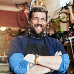 Bicycle shop owner stands with arms crossed