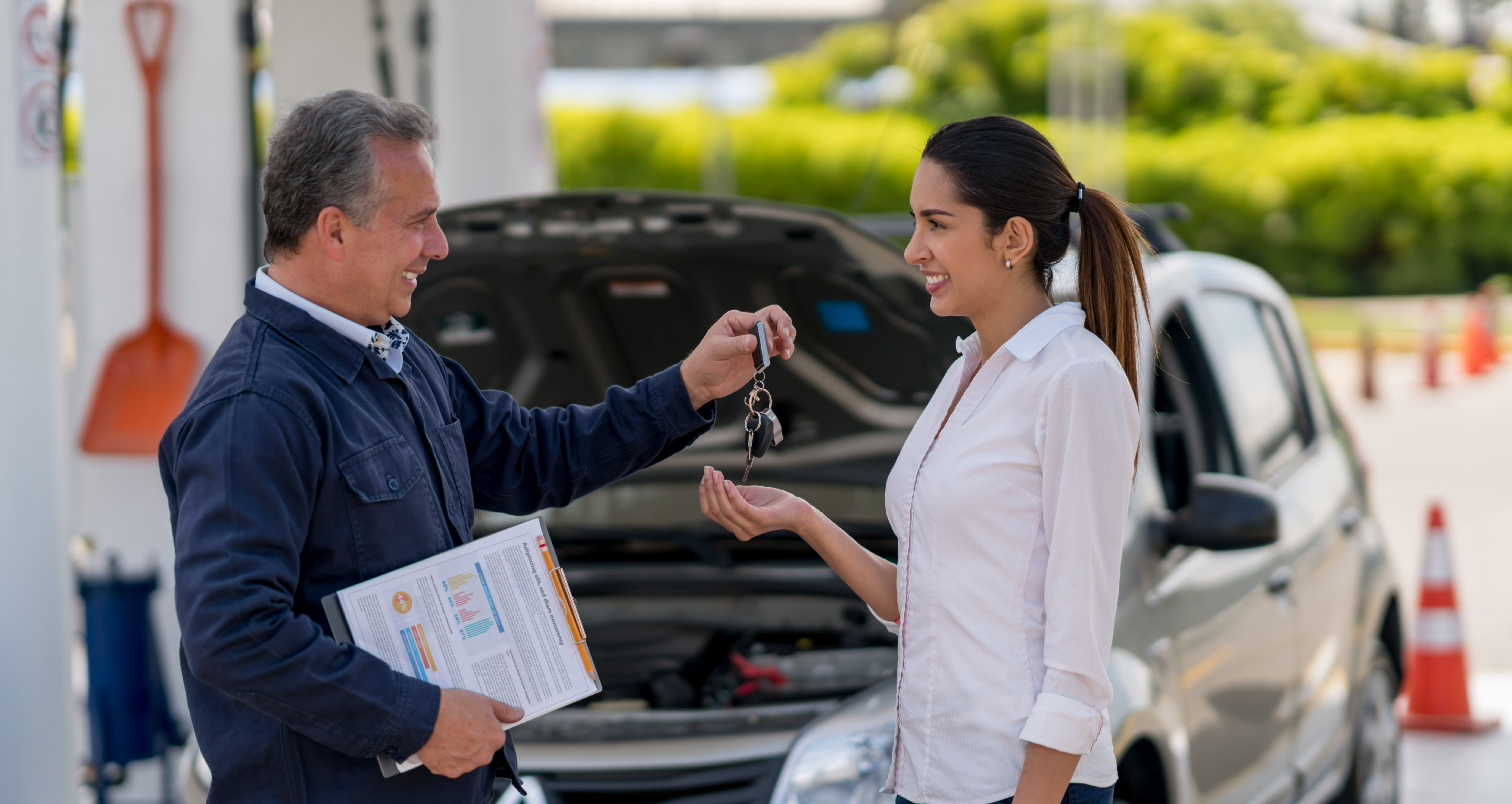 Car salesman handing keys to new car owner