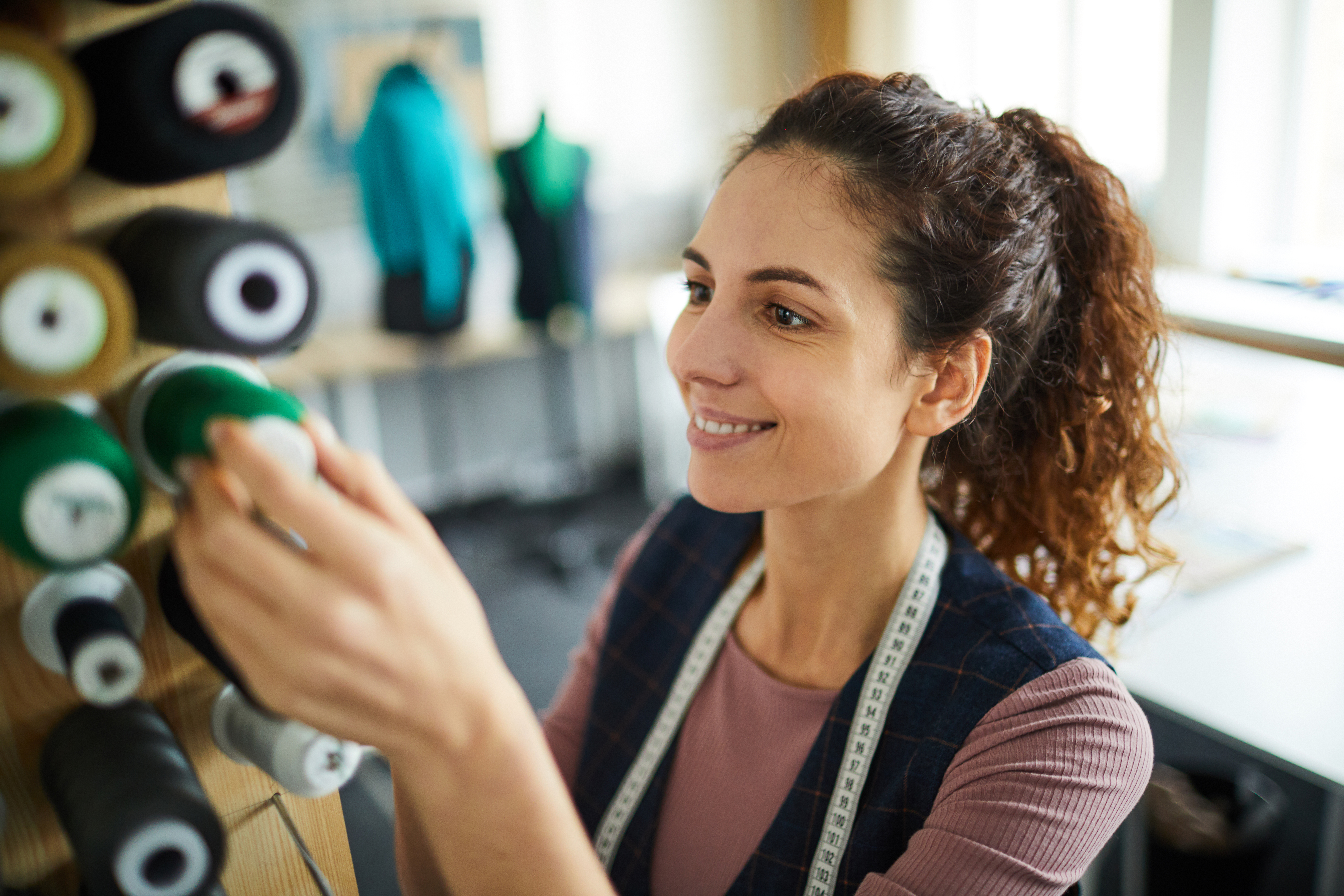 woman pulling yarn from a spindle