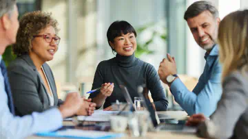 People sit around a conference table.